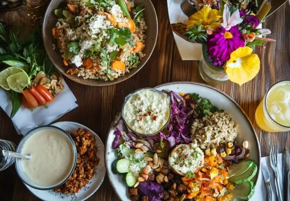 Bogato obložena miza s pisanimi zelenjavnimi jedmi.